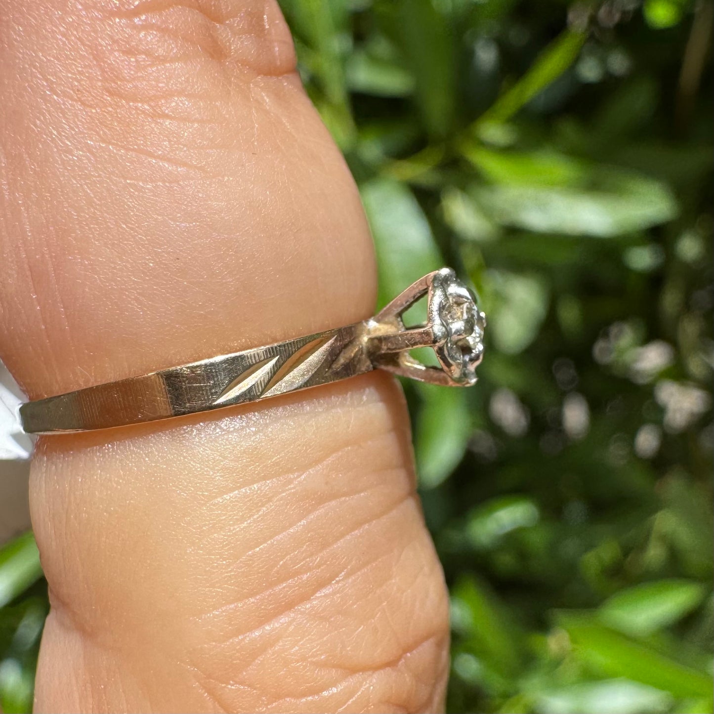 14K gold ring with a delicate floral-style setting, set with a small central Diamond.