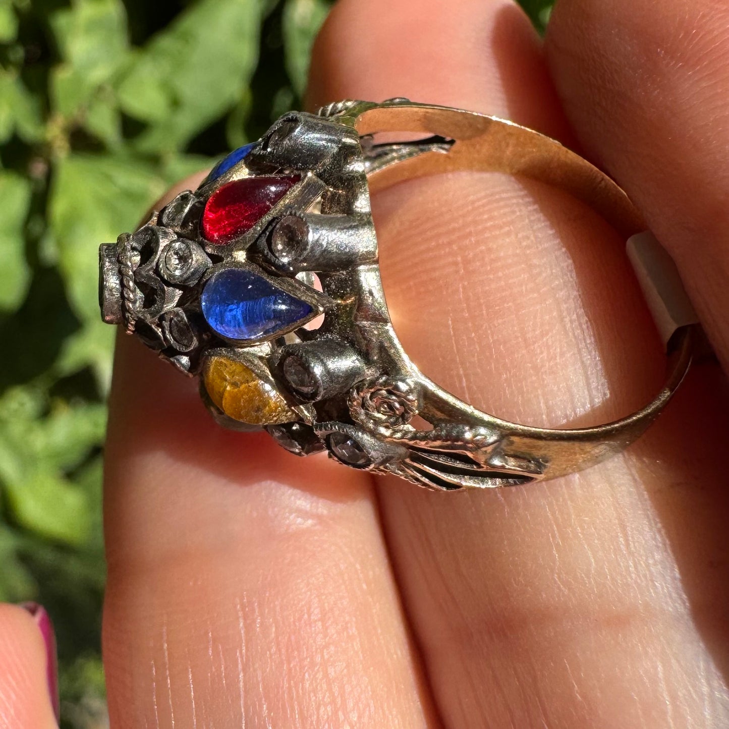 14K gold ring set with a central transparent gemstone surrounded by a vibrant mosaic of colorful gemstones -set in an ornate, handcrafted design