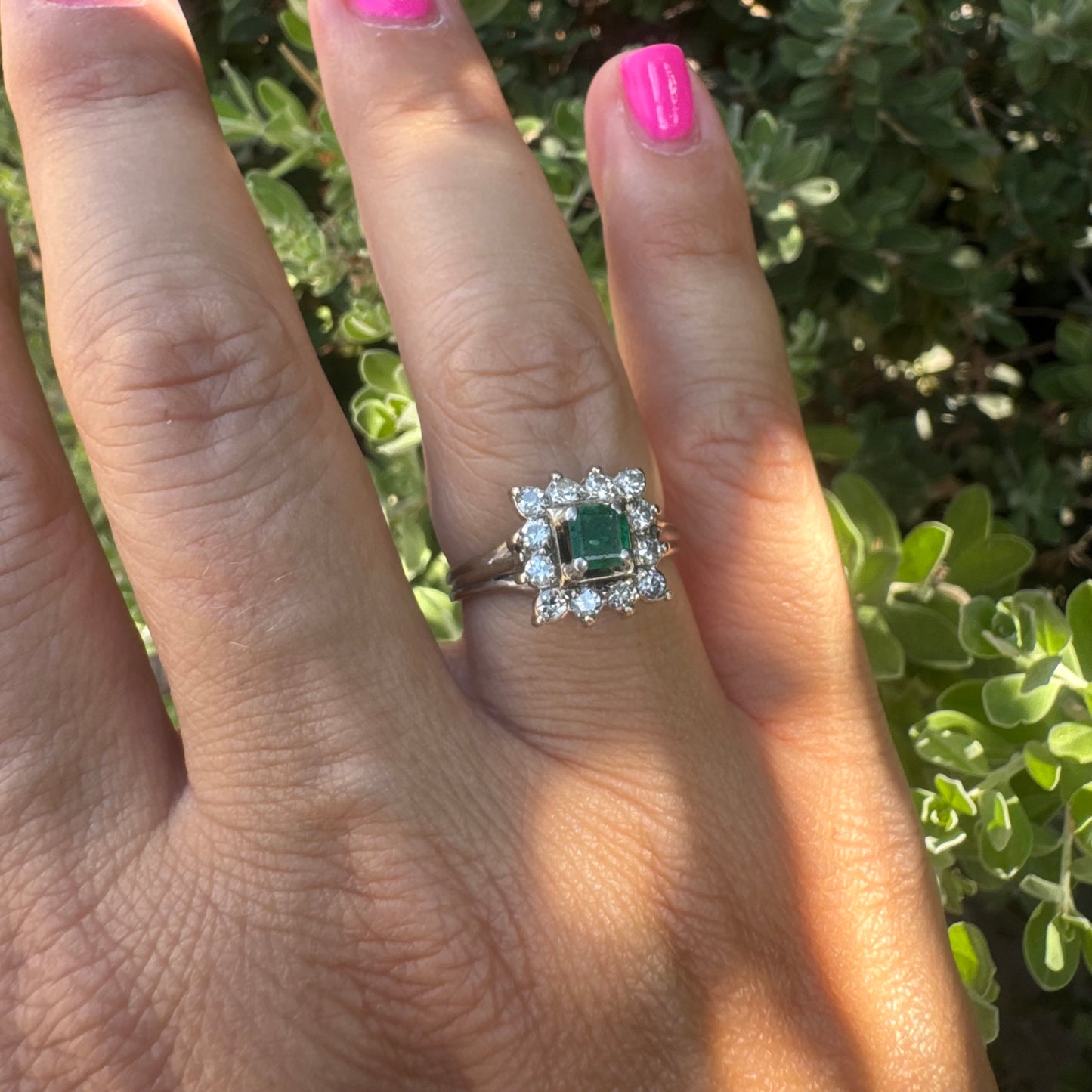 18K gold ring set with a vibrant square-cut Emerald surrounded by a sparkling halo of Diamonds.