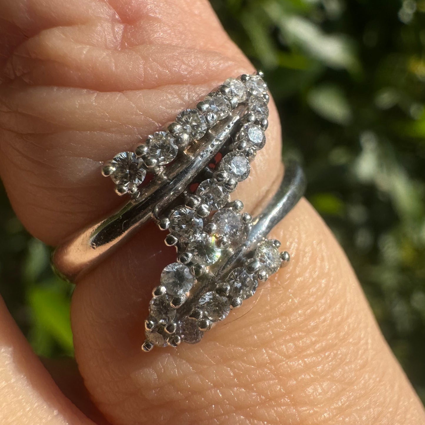 14K gold ring with an open design, featuring two curved rows of sparkling Diamonds that cross over each other elegantly.