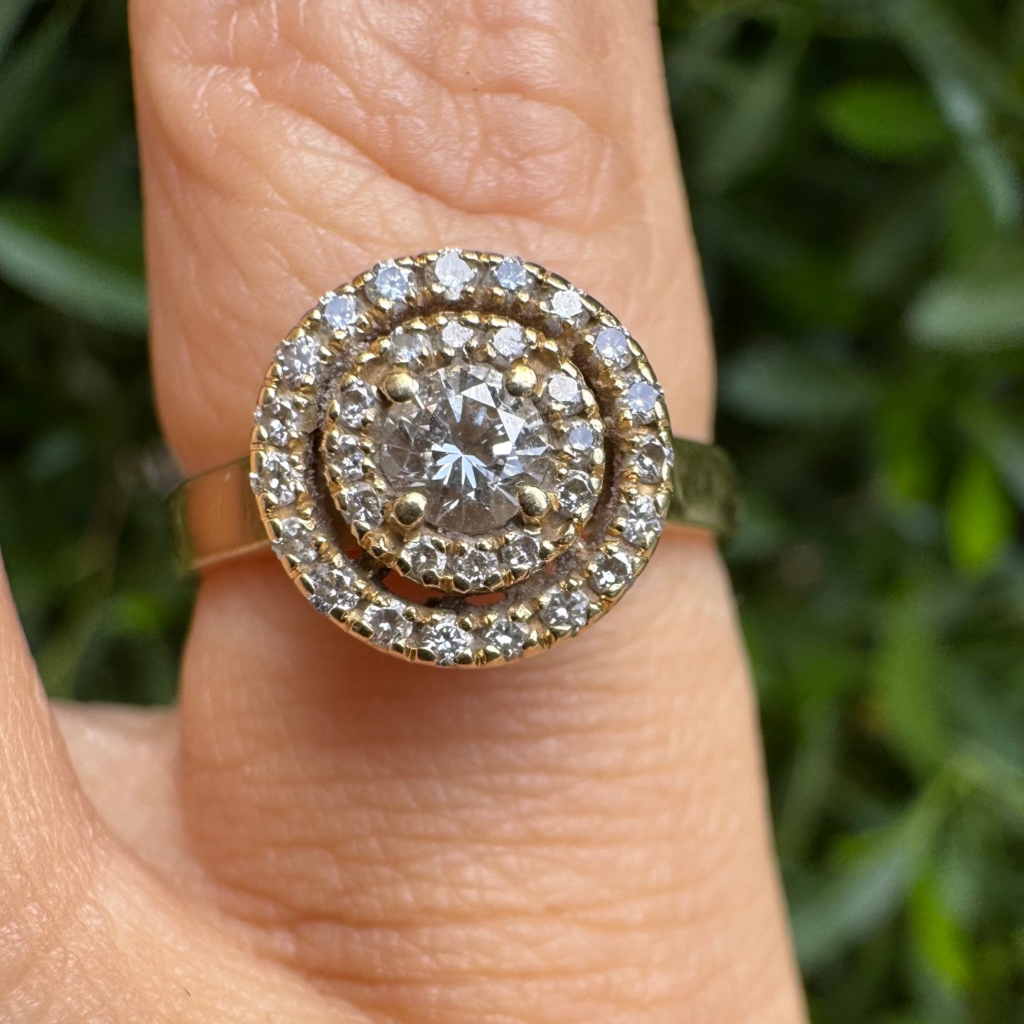 14K gold ring with a round center Diamond, surrounded by two rows of small sparkling Diamonds.