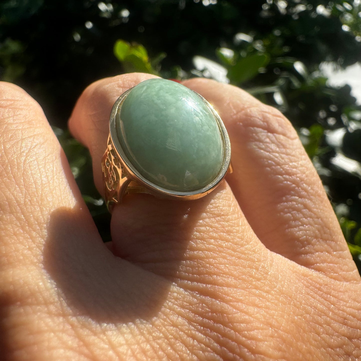 14K gold ring featuring a large oval light green Jade with a smooth polished finish, set in a classic bezel setting.