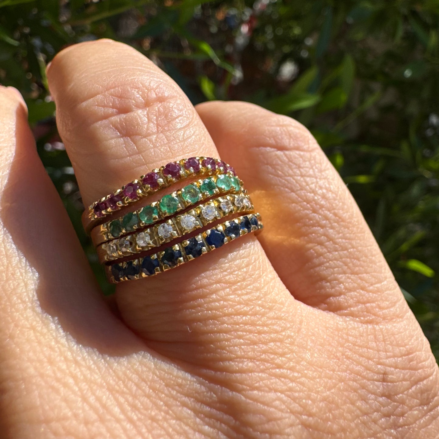 18K yellow gold ring set with vibrant rows of Sapphires, Emeralds, Rubies, and Diamonds
