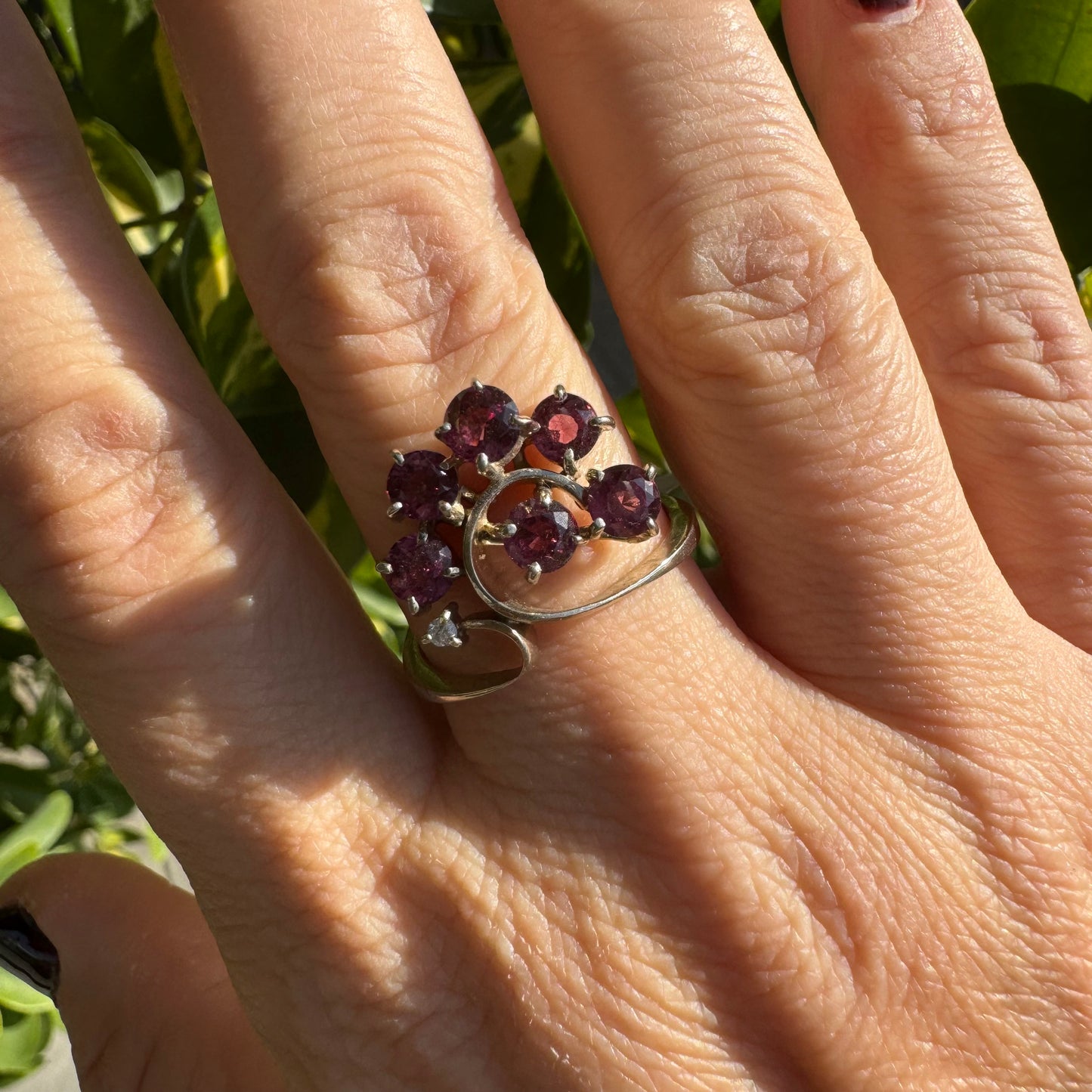 14K gold ring with an open, flowing design, set with multiple pink Tourmaline stones and accented by a Diamond