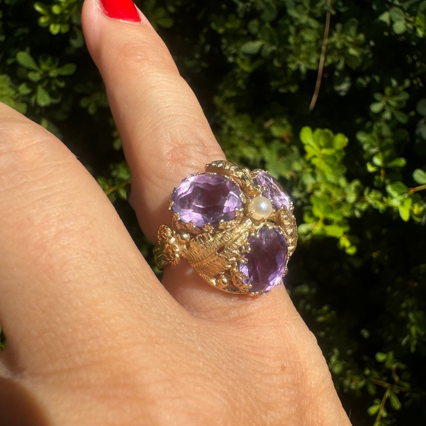 14K gold ring set with four glowing Amethyst stones encircling a delicate central Pearl.