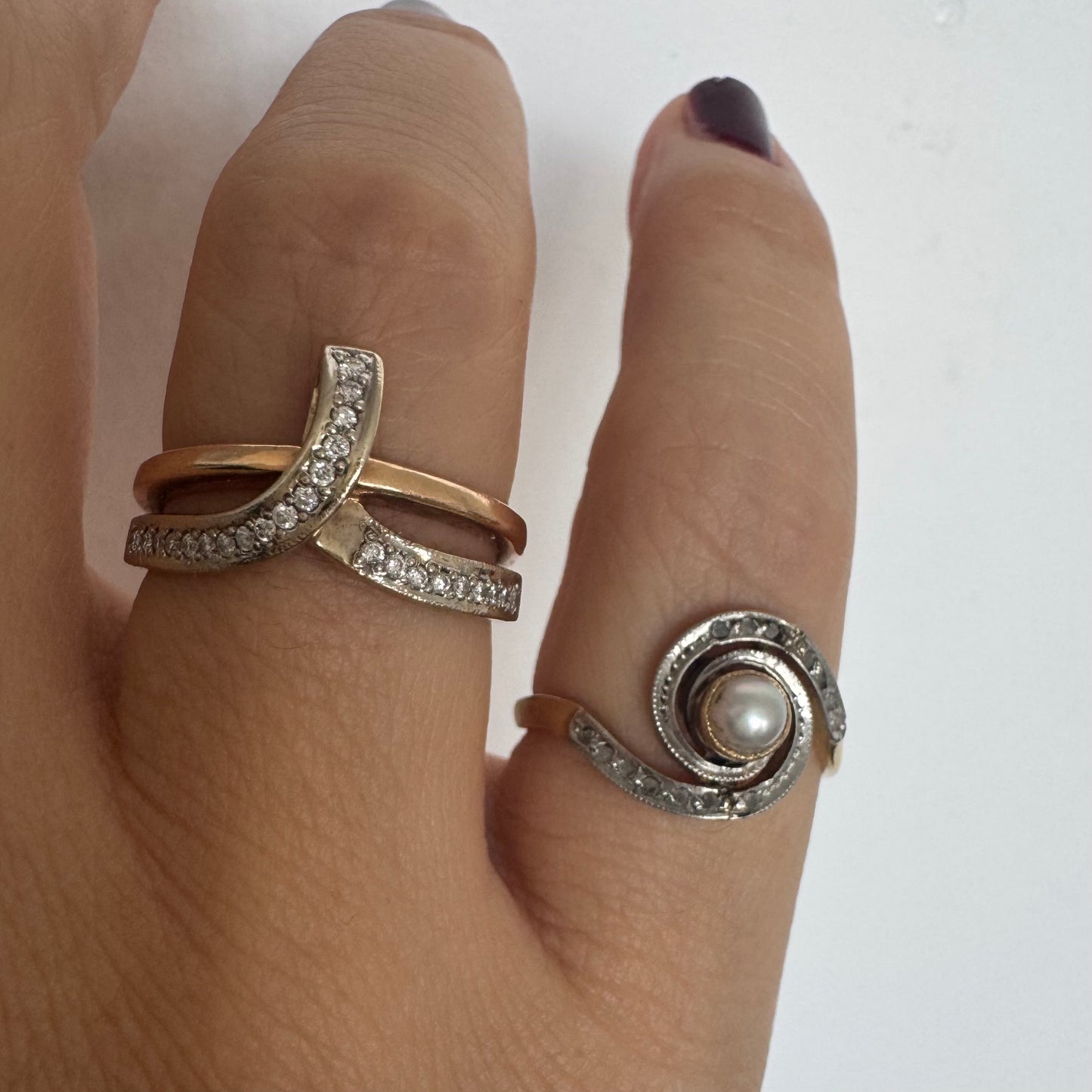 טבעת זהב צהוב 18 קראט בסגנון ספירלה, משובצת פנינה במרכז, מוקפת בשיבוץ של יהלומים .