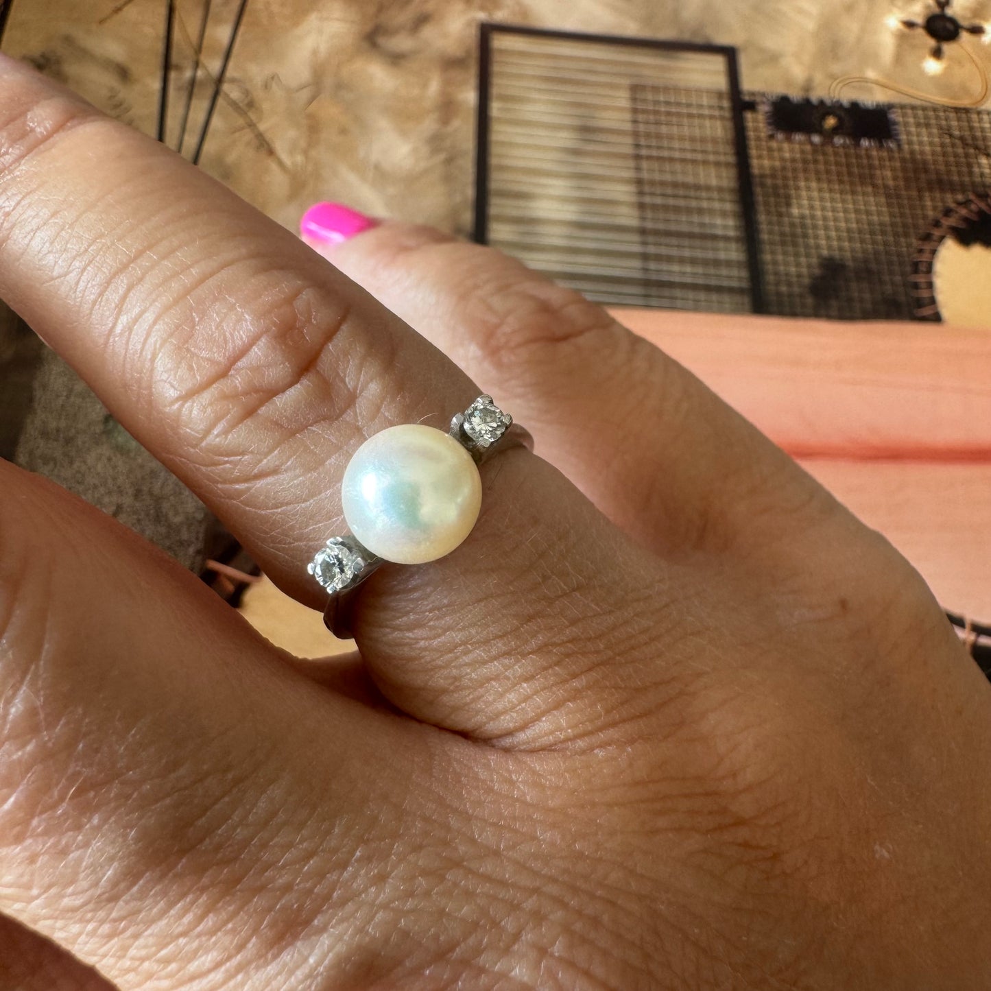18K gold ring featuring a round Pearl at the center, flanked by two Diamonds.