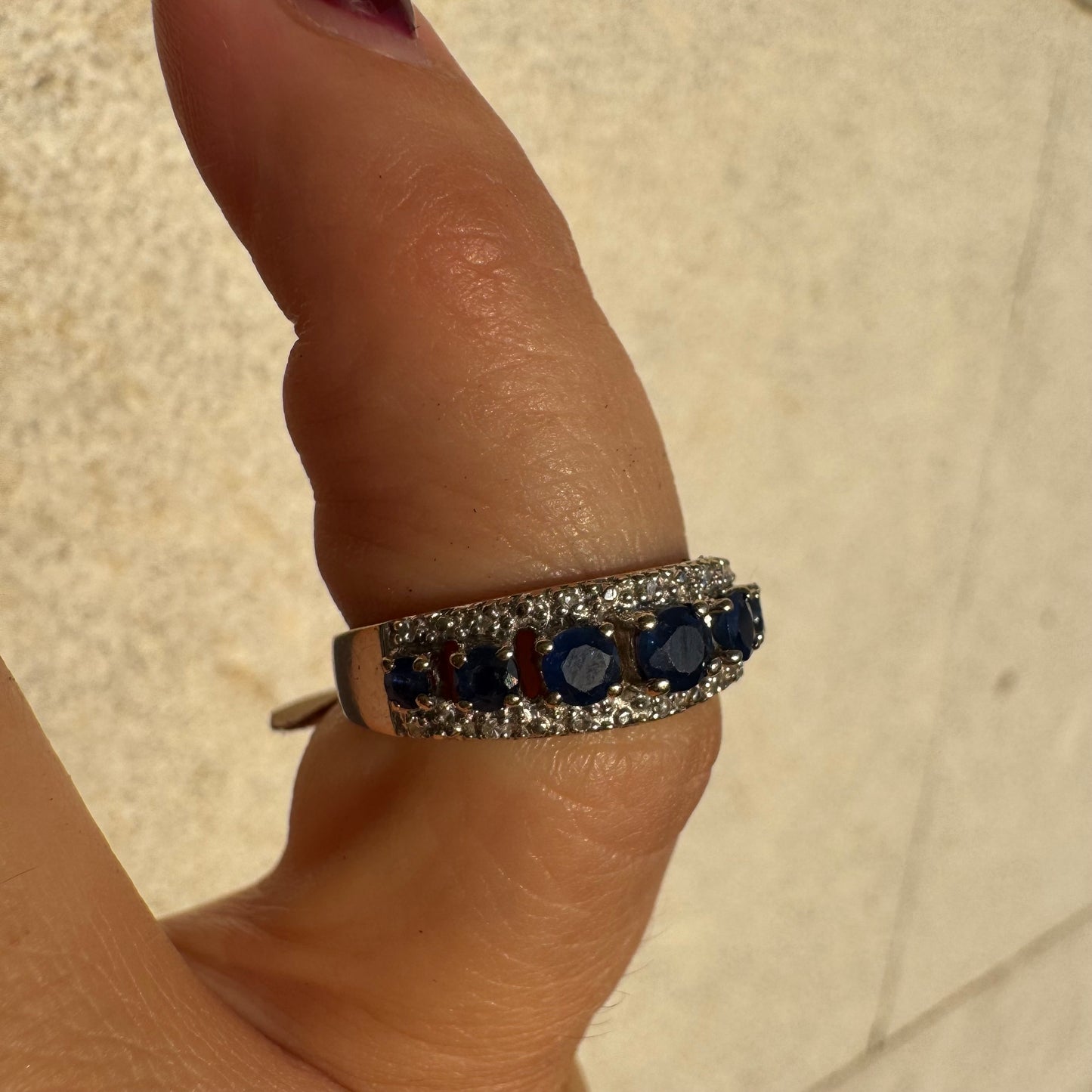 18K gold ring set with deep blue sapphires in a classic round cut, framed by two shimmering rows of brilliant Diamonds.