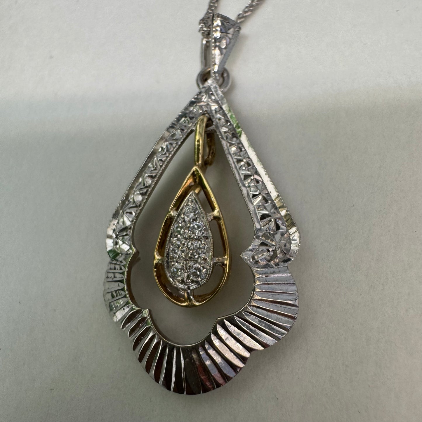 14K white and yellow gold pendant in a unique geometric design set with Diamonds