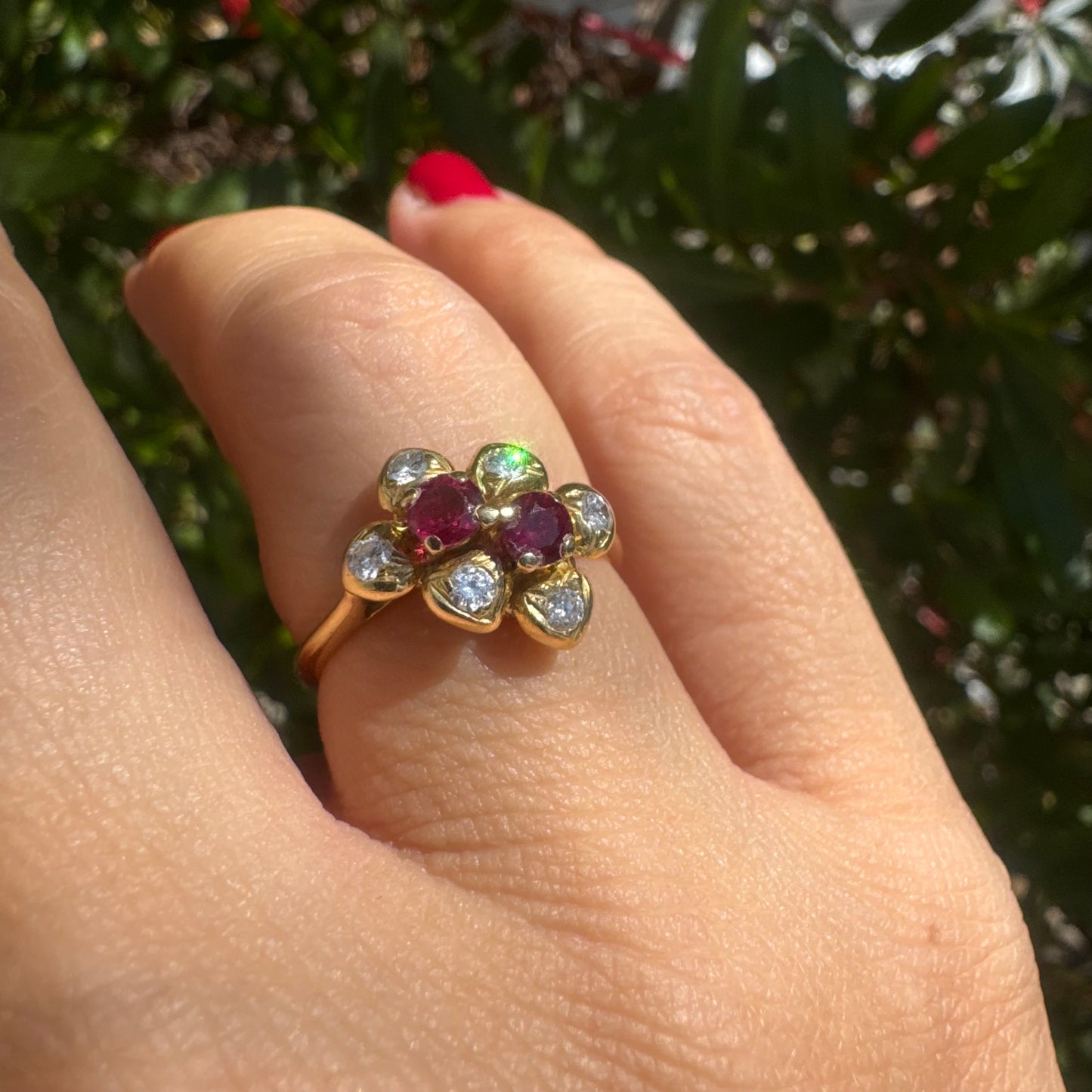 18K gold ring designed like a flower, set with two deep red Rubies and sparkling Diamonds