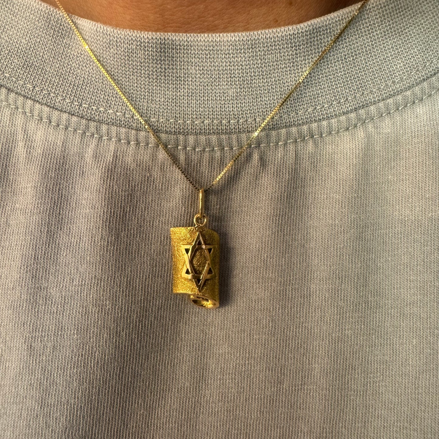 18K gold handcrafted pendant in the shape of a scroll, featuring a raised Star of David.