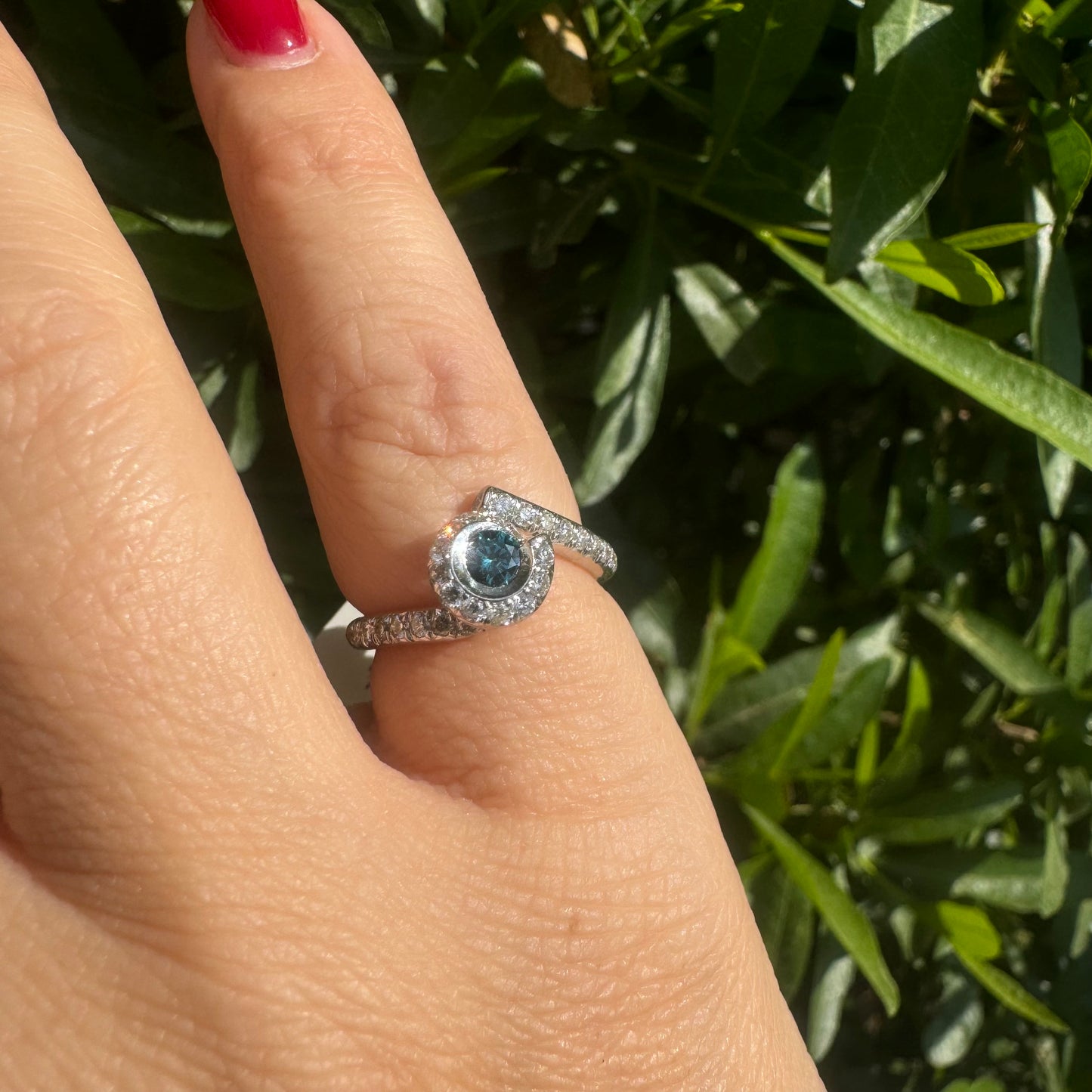 18K gold ring set with a vivid blue Diamond at its heart, embraced by a shimmering halo of white diamonds and a bold open design