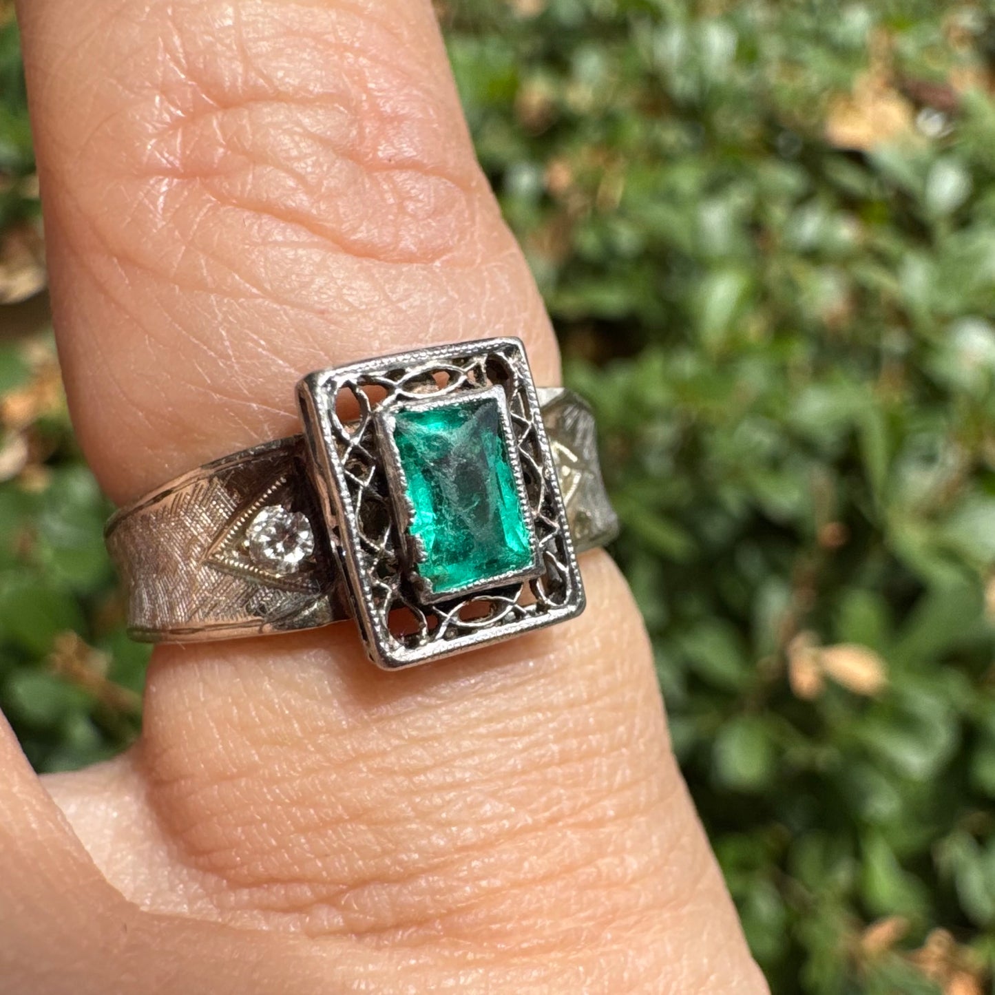 14K gold ring set with a vibrant emerald-cut Emerald at its center, framed by delicate filigree work