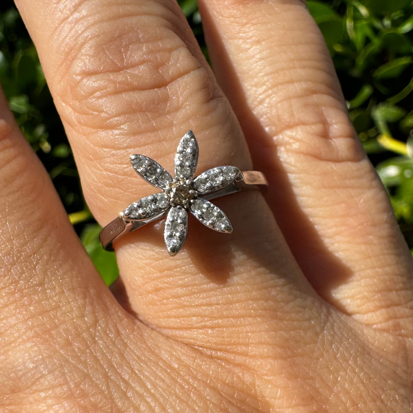 14K gold ring set with a floral design with six petal-shaped segments, each pavé-set with shimmering Diamonds