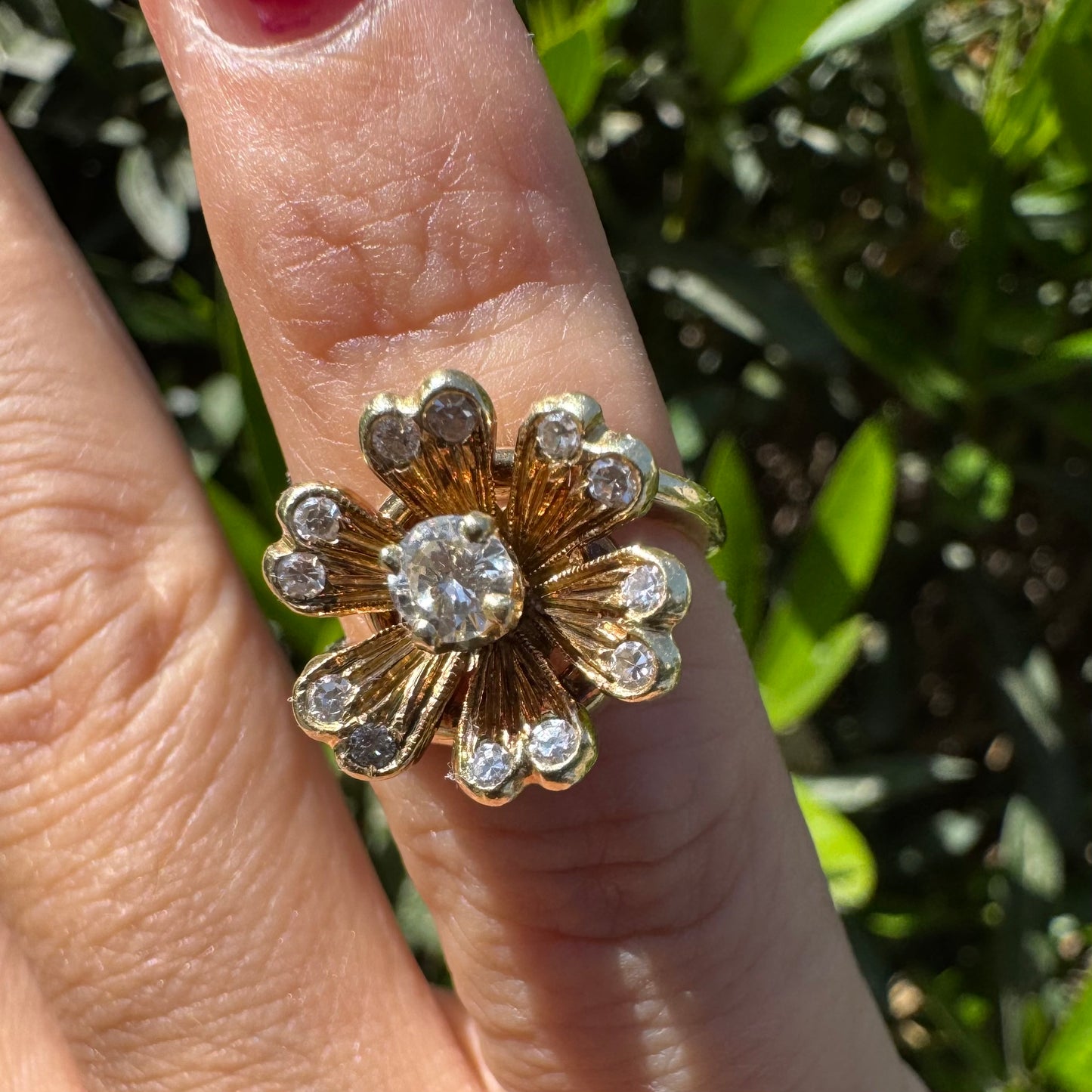 14K gold ring in a floral design, set with sparkling Diamonds at the center and around the petals.