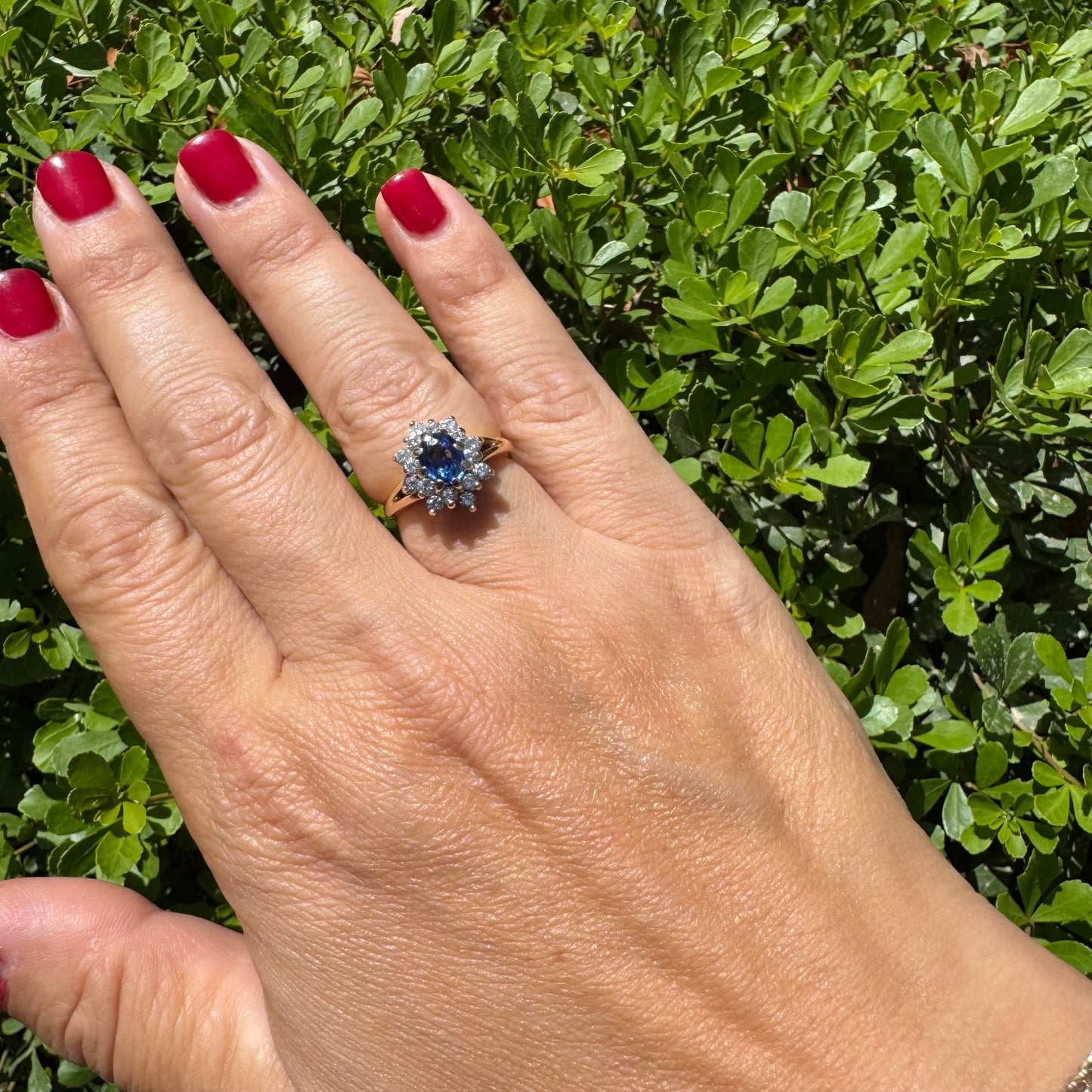 14K gold ring set with a vivid blue Sapphire surrounded by a sparkling halo of brilliant-cut Diamonds