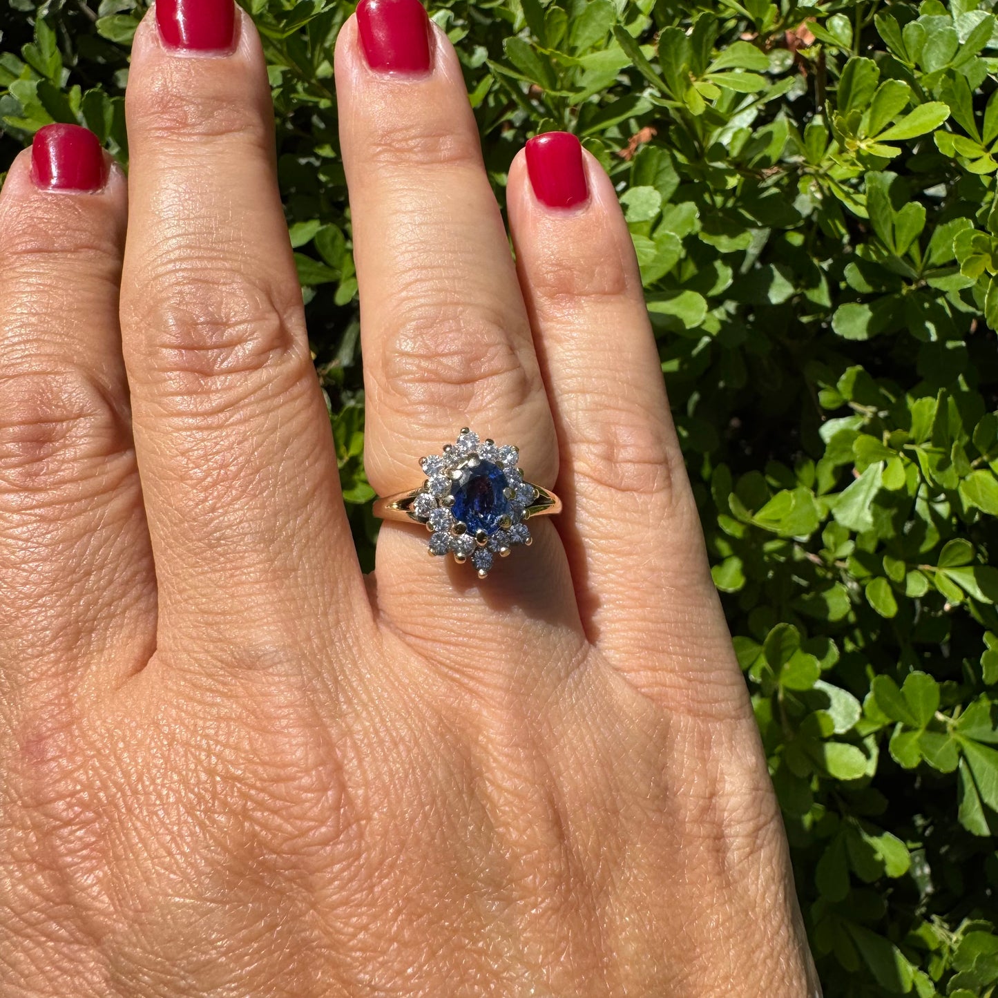 14K gold ring set with a vivid blue Sapphire surrounded by a sparkling halo of brilliant-cut Diamonds