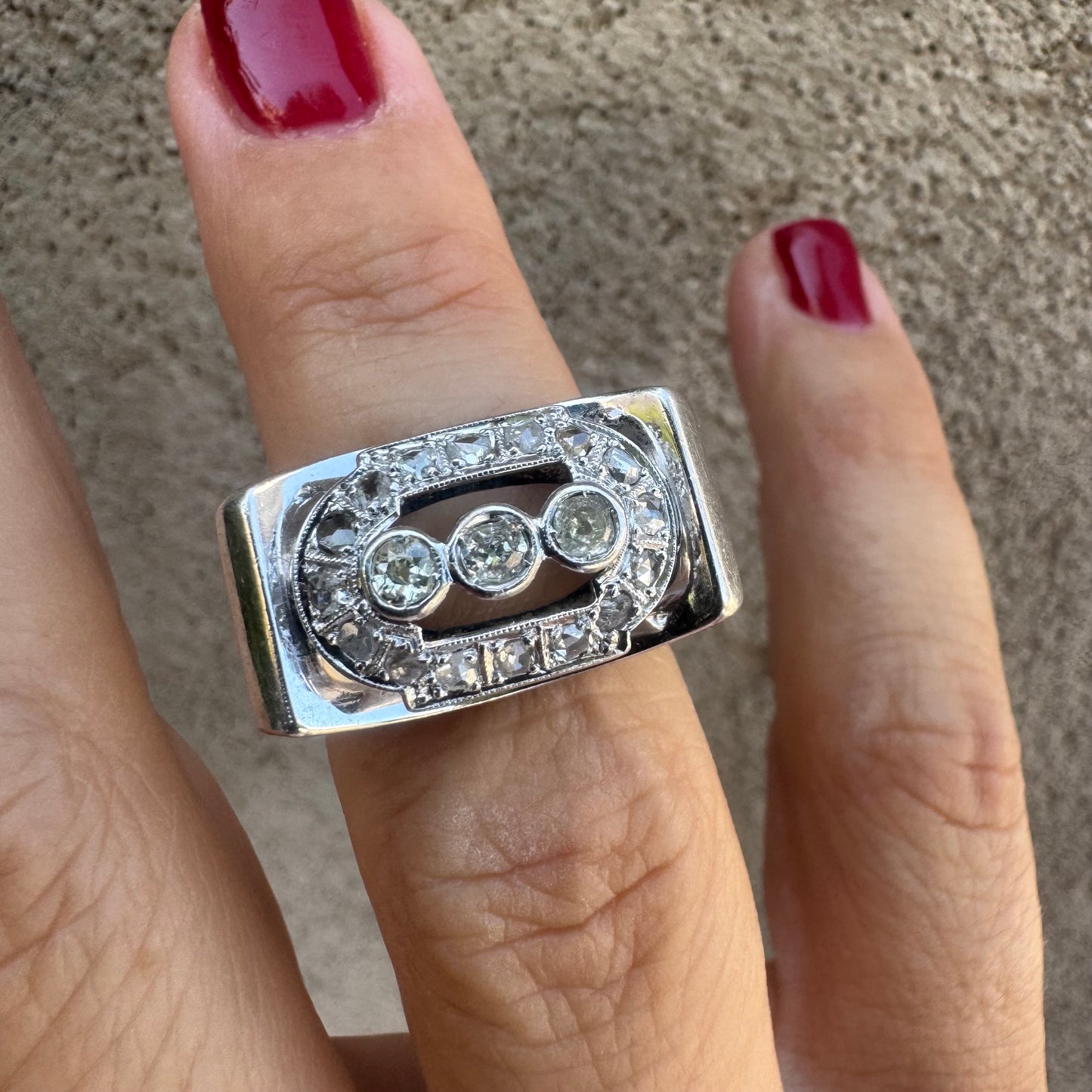 18K gold ring featuring three round 3 Diamonds in the center, framed by a rectangular halo of smaller Diamonds.