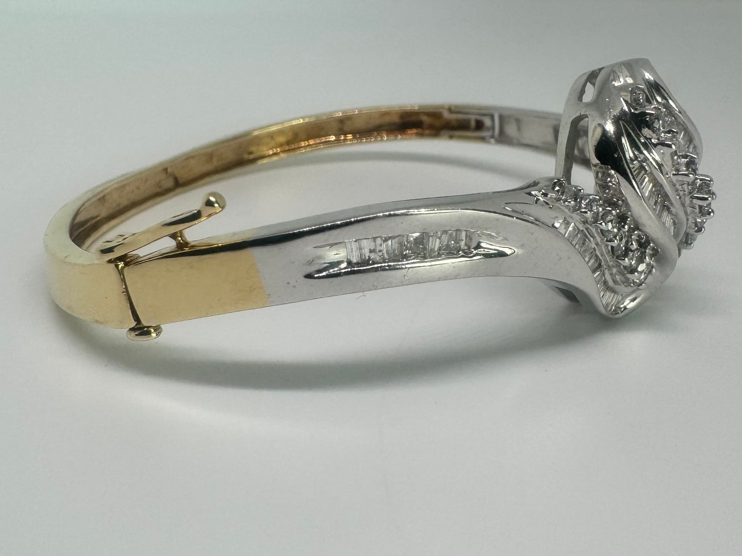 צמיד מרהיב מזהב לבן 14 קראט, בעיצוב גלים דינמי המשובץ בשיבוץ מרוכב של יהלומים עגולים ובחיתוך באגט.