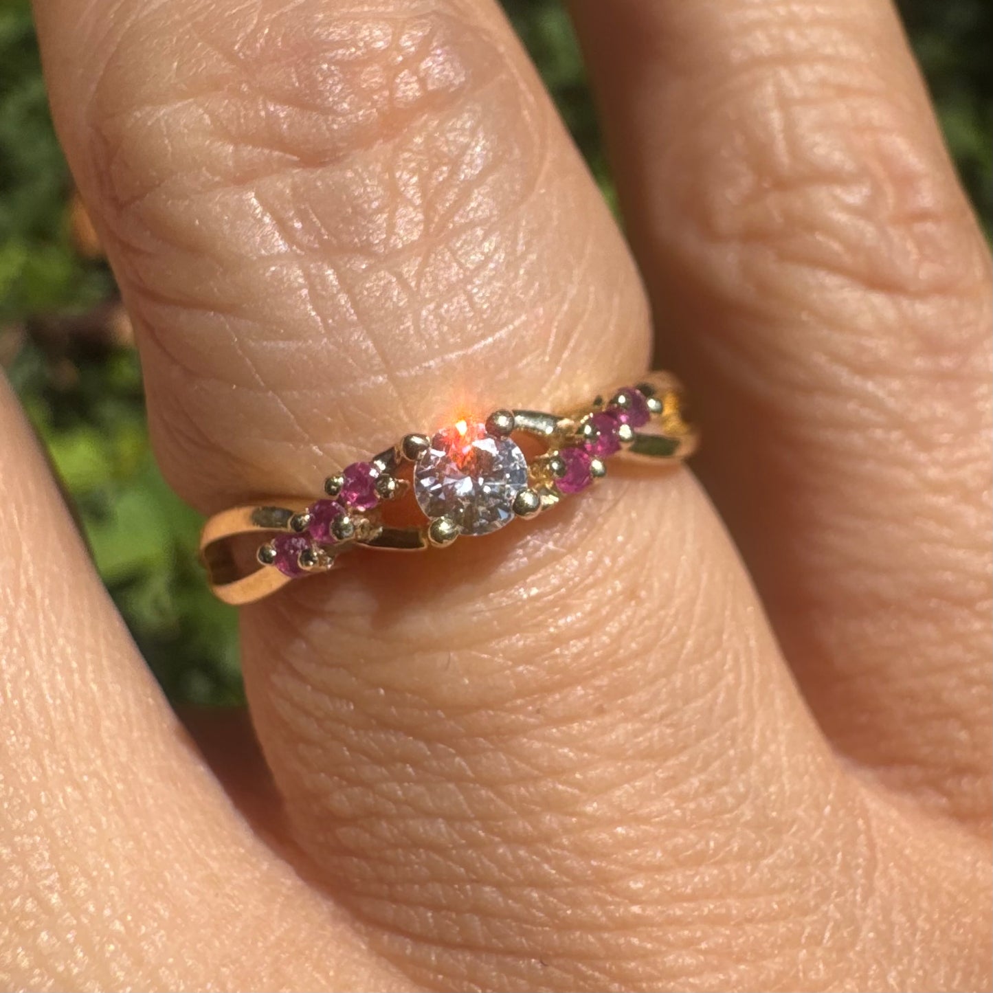 14K gold ring set with a central round Diamond, accented with Rubies along the band.