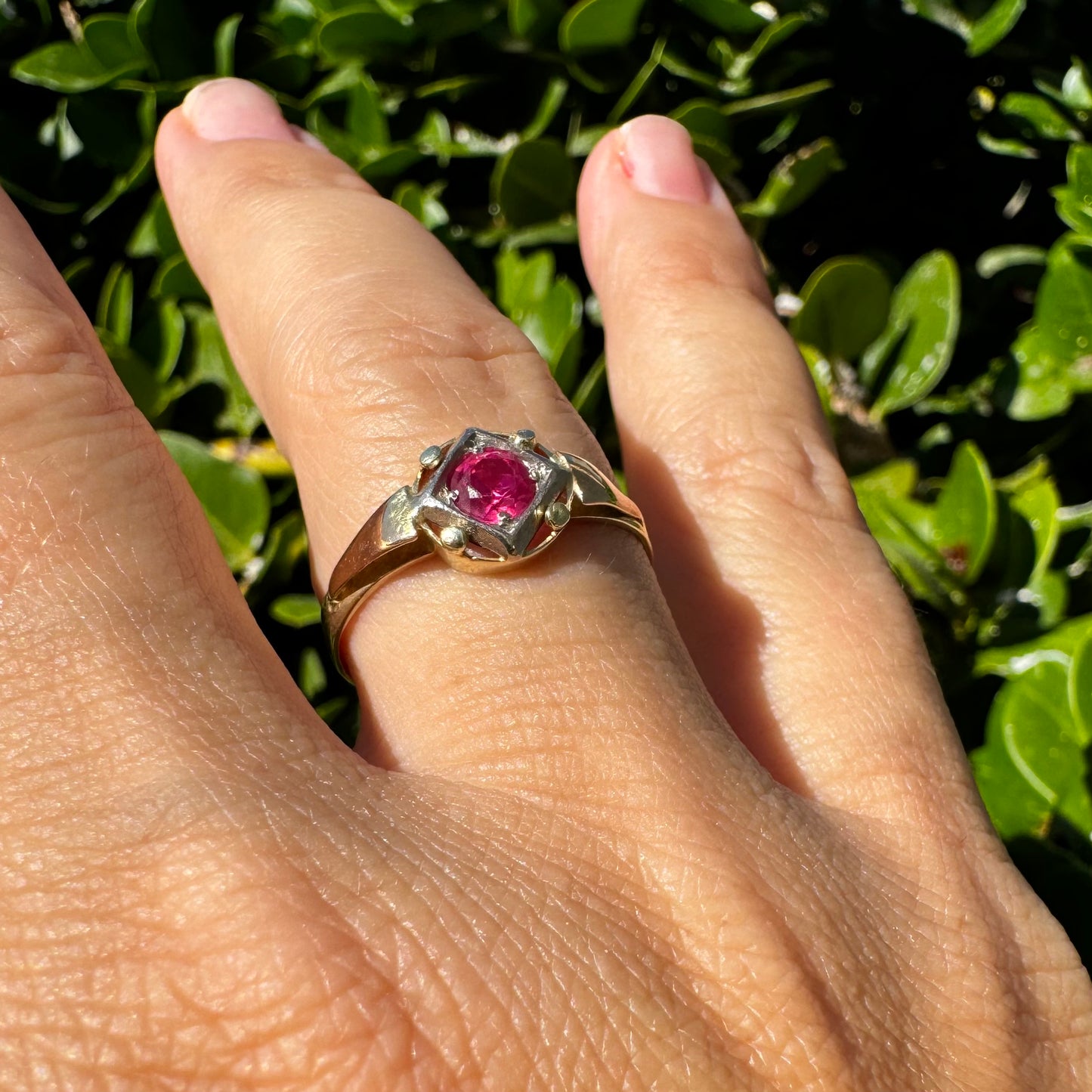 14K gold ring set with a vivid round-cut Ruby set in a geometric white gold frame.