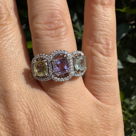 18K gold ring set with three pastel gemstones in soft shades of lilac, yellow and light gray