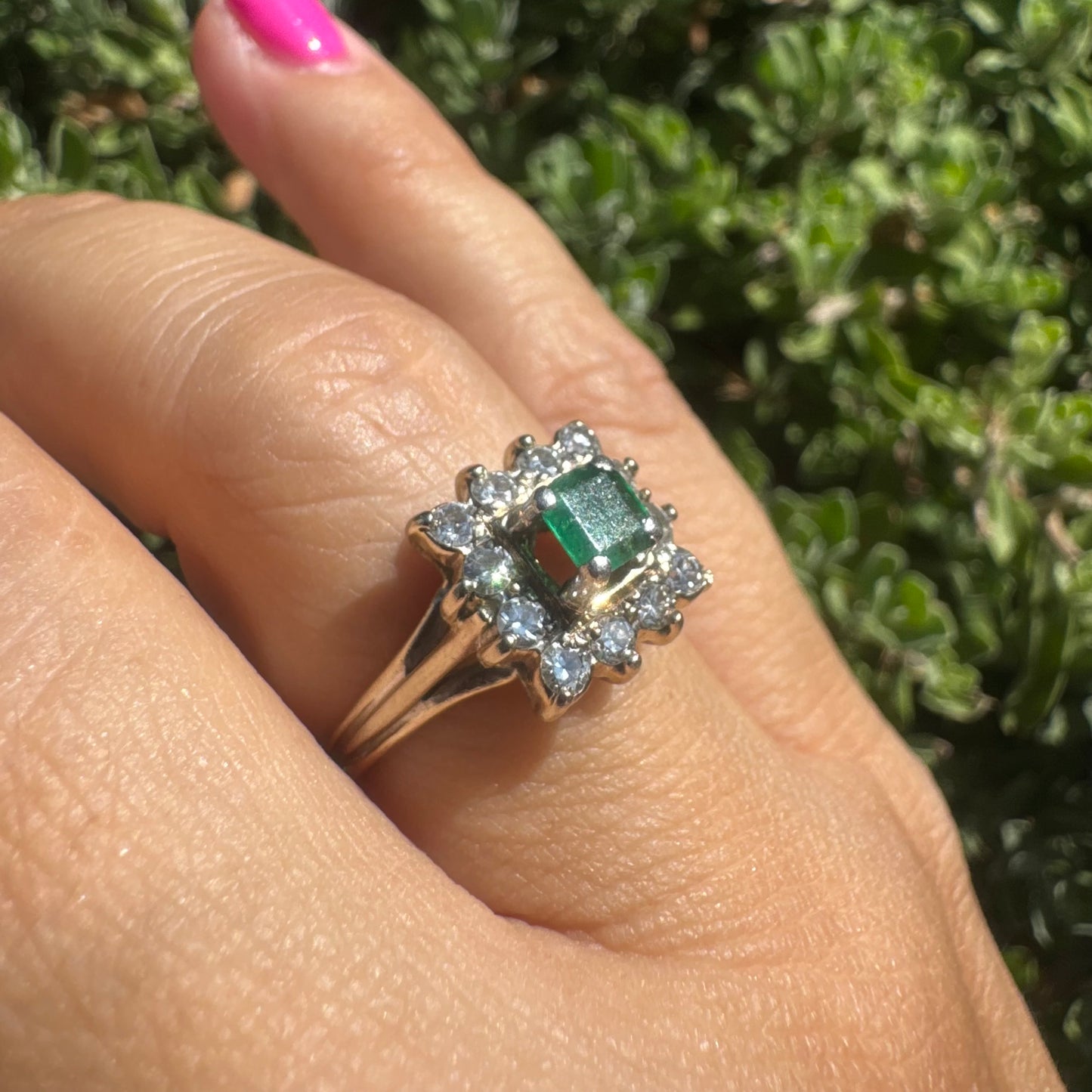 18K gold ring set with a vibrant square-cut Emerald surrounded by a sparkling halo of Diamonds.