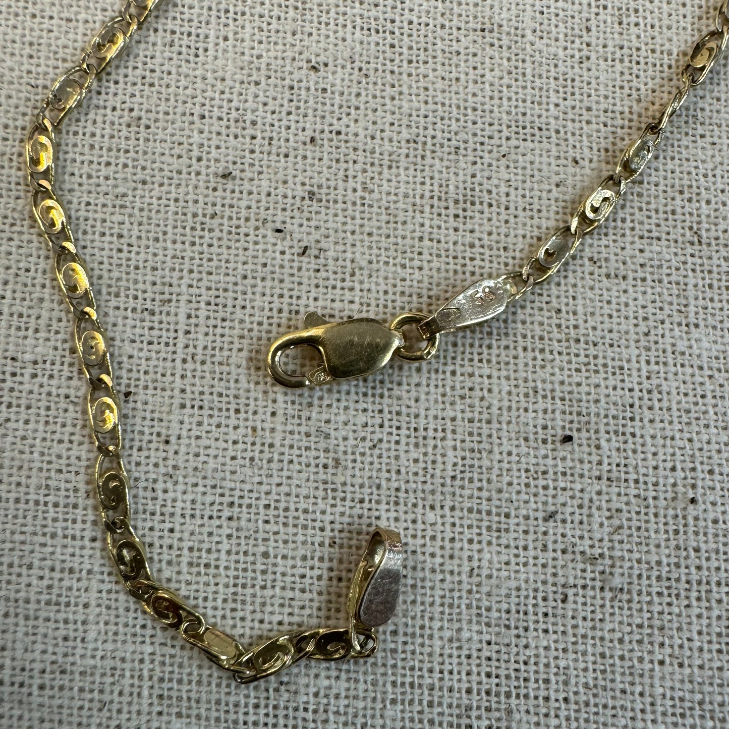 14K gold necklace featuring oval-shaped links with a subtle decorative pattern.