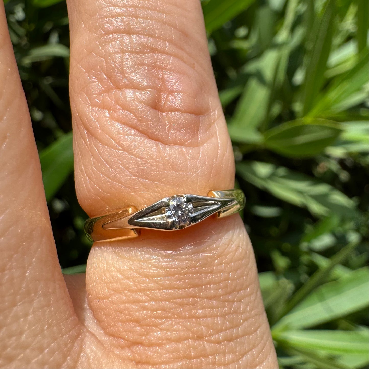 18K gold ring featuring a single round Diamond