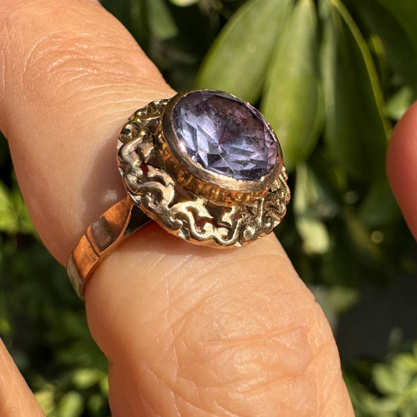 14K gold ring set with a large round-cut Tanzanite framed by an ornate filigree bezel