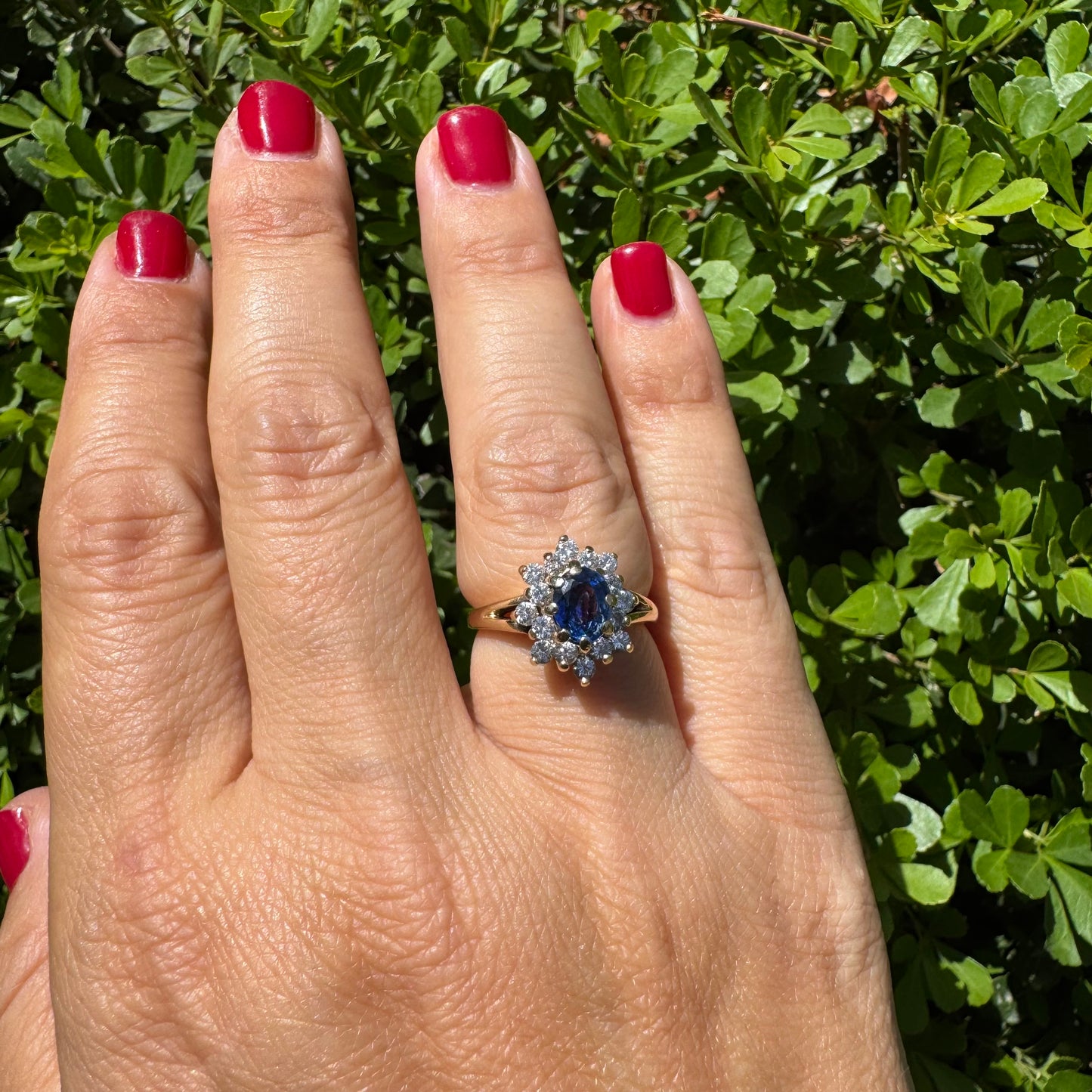 14K gold ring set with a vivid blue Sapphire surrounded by a sparkling halo of brilliant-cut Diamonds