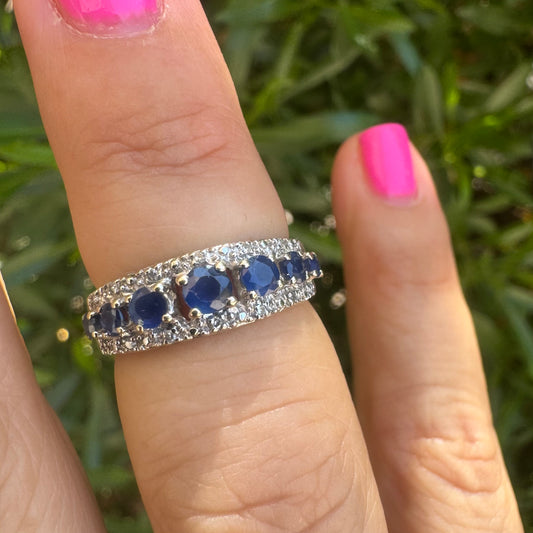 18K gold ring set with deep blue sapphires in a classic round cut, framed by two shimmering rows of brilliant Diamonds.
