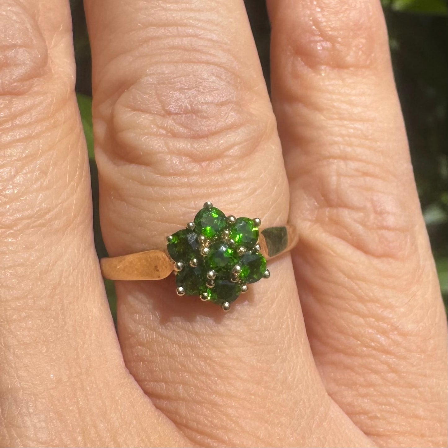 10K gold ring set with vivid green gemstones in a delicate floral cluster
