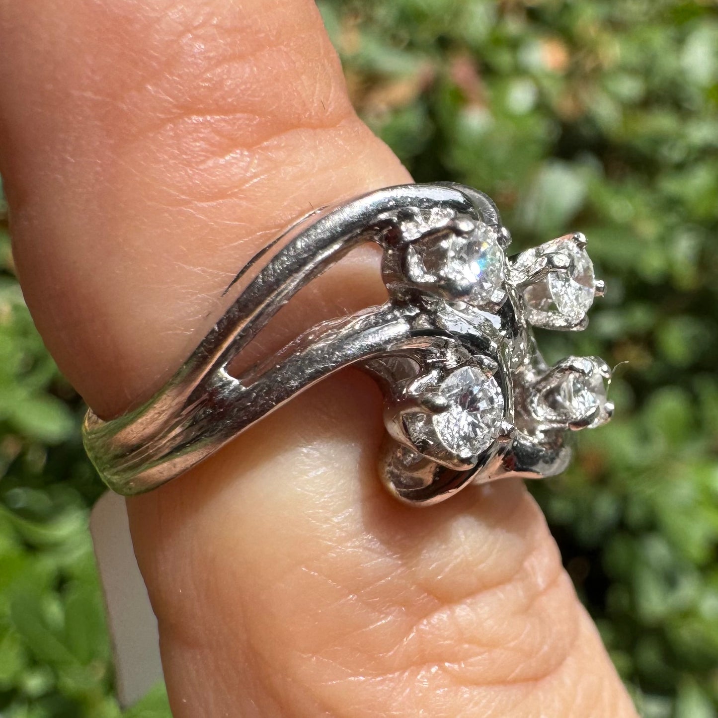 14K gold ring set with four brilliant-cut Diamonds, arranged in an elegant flowing design