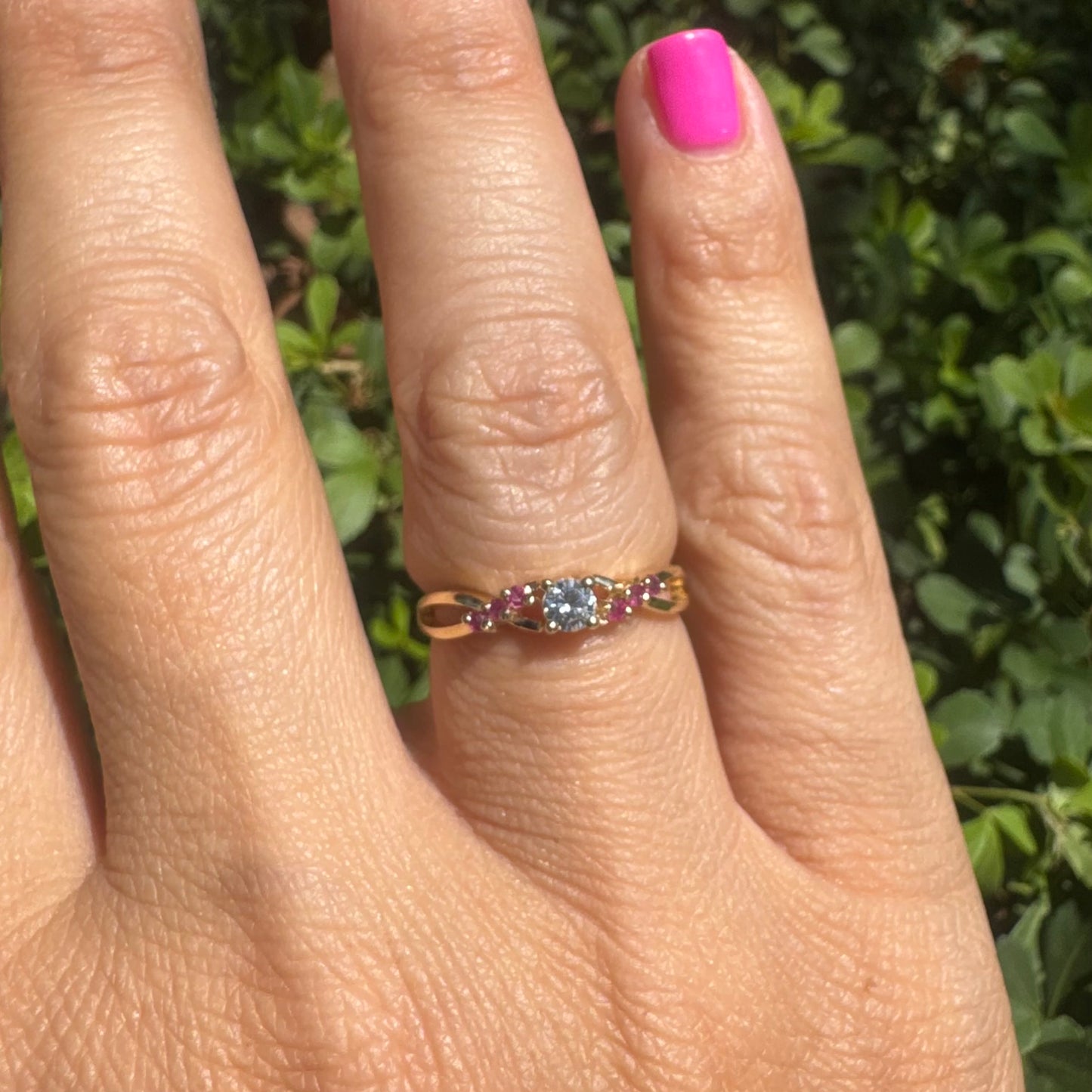 14K gold ring set with a central round Diamond, accented with Rubies along the band.