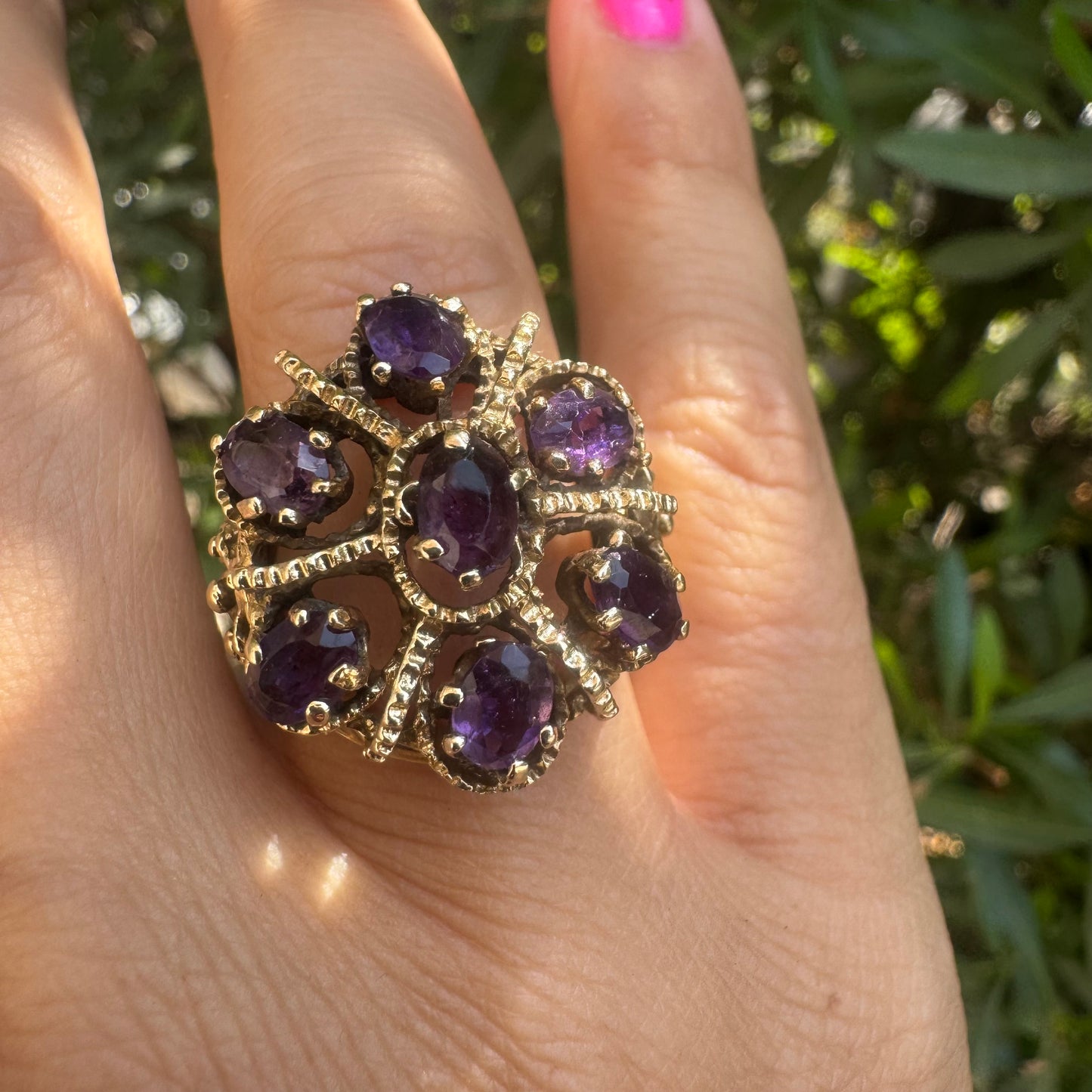 14K gold ring set with deep purple amethysts in an ornate floral design.