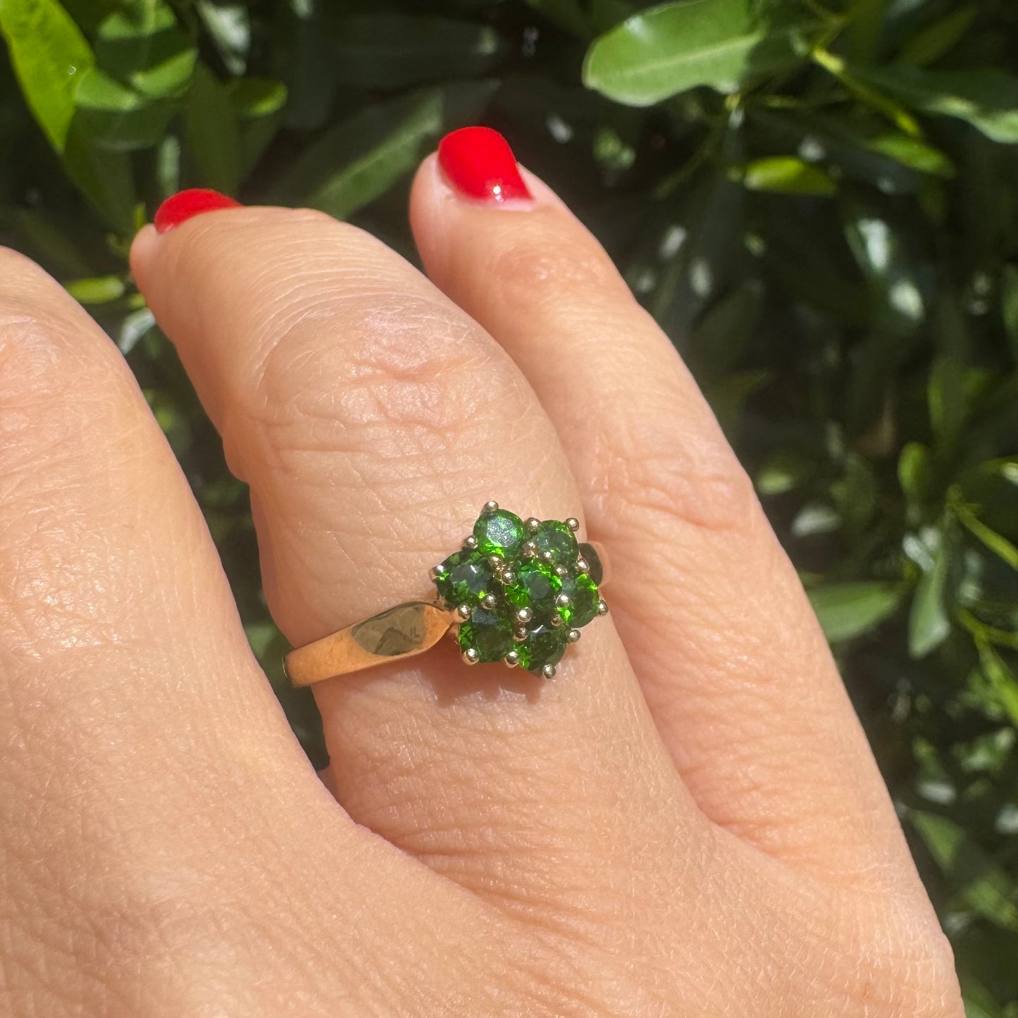 10K gold ring set with vivid green gemstones in a delicate floral cluster