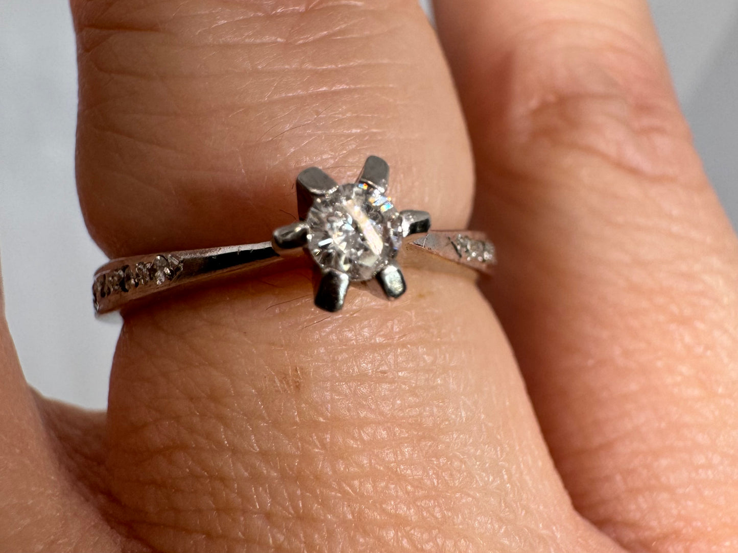 טבעת זהב לבן 14 קראט משובצת יהלום מרכזי ויהלומים בצדדים