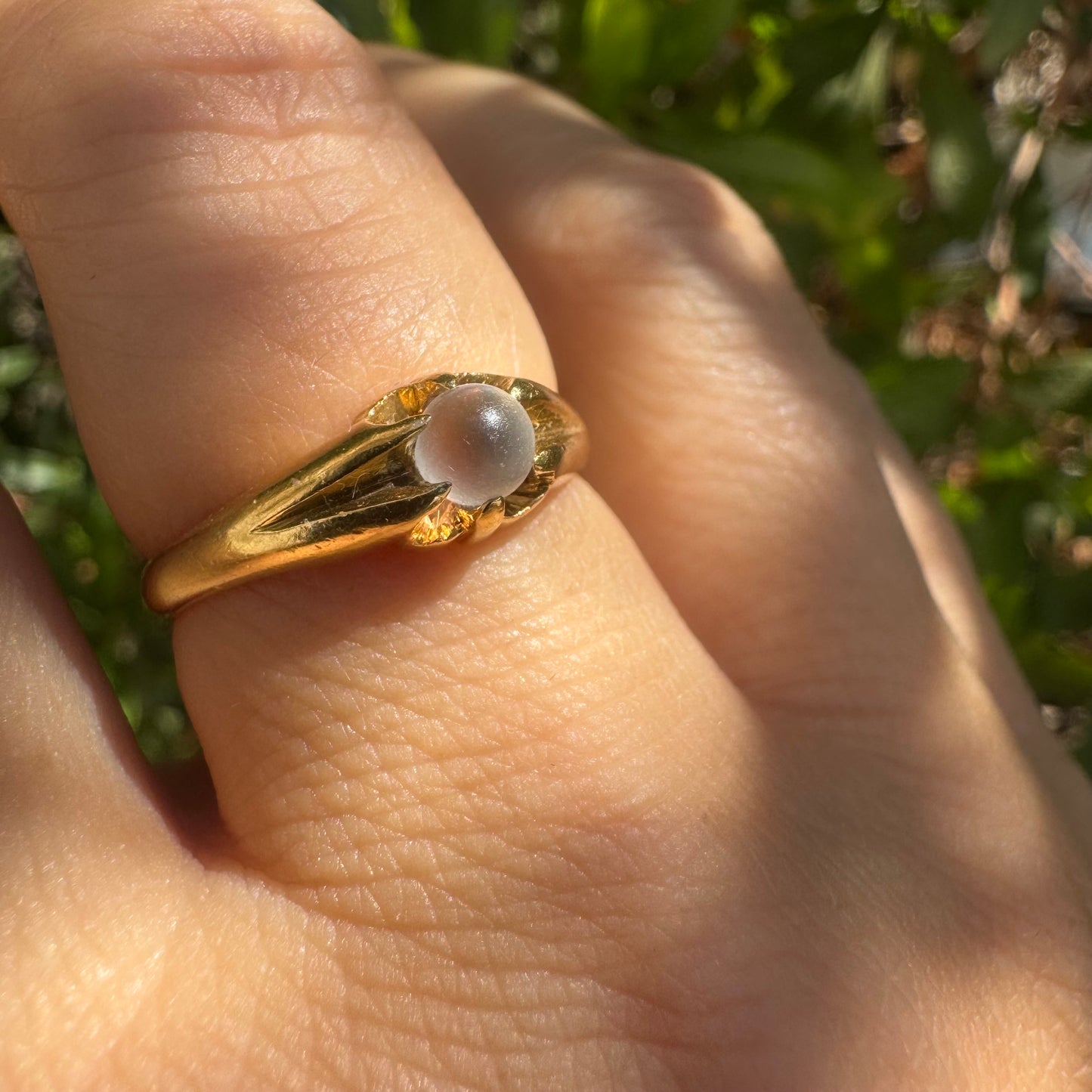 18K yellow gold ring featuring a smooth round Moonstone set in a delicate floral-inspired design.
