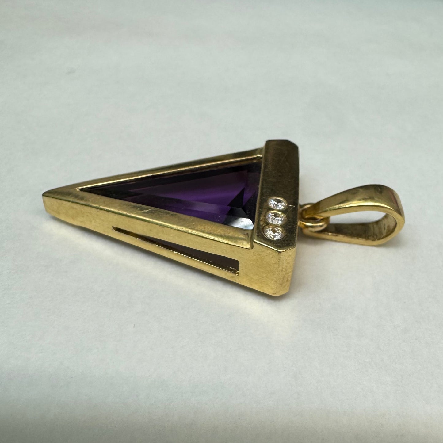 14K yellow gold pendant set with a triangular-cut amethyst and three accent diamonds