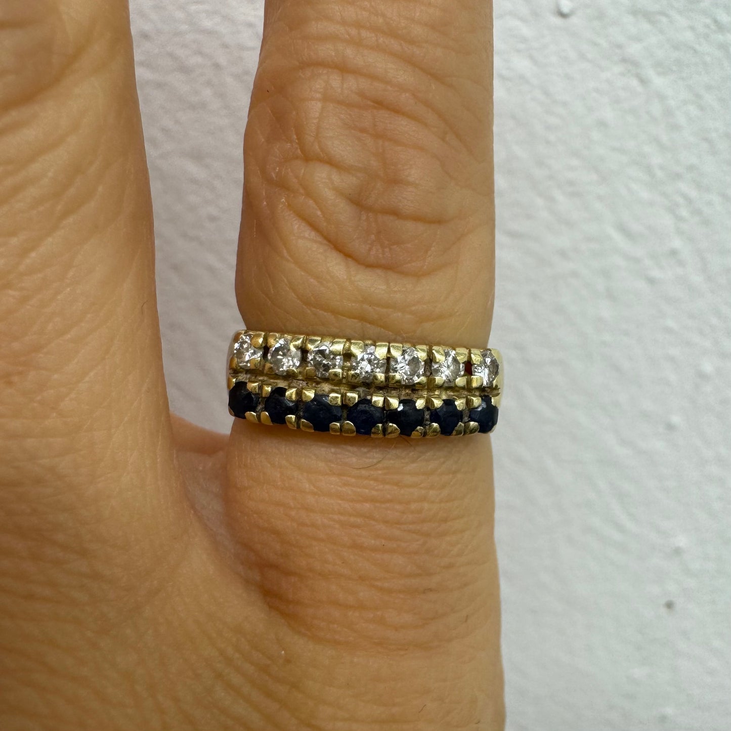 טבעת זהב צהוב 14 קראט, עם שורה של יהלומים נוצצים ושורה נוספת של ספירים כחולים.