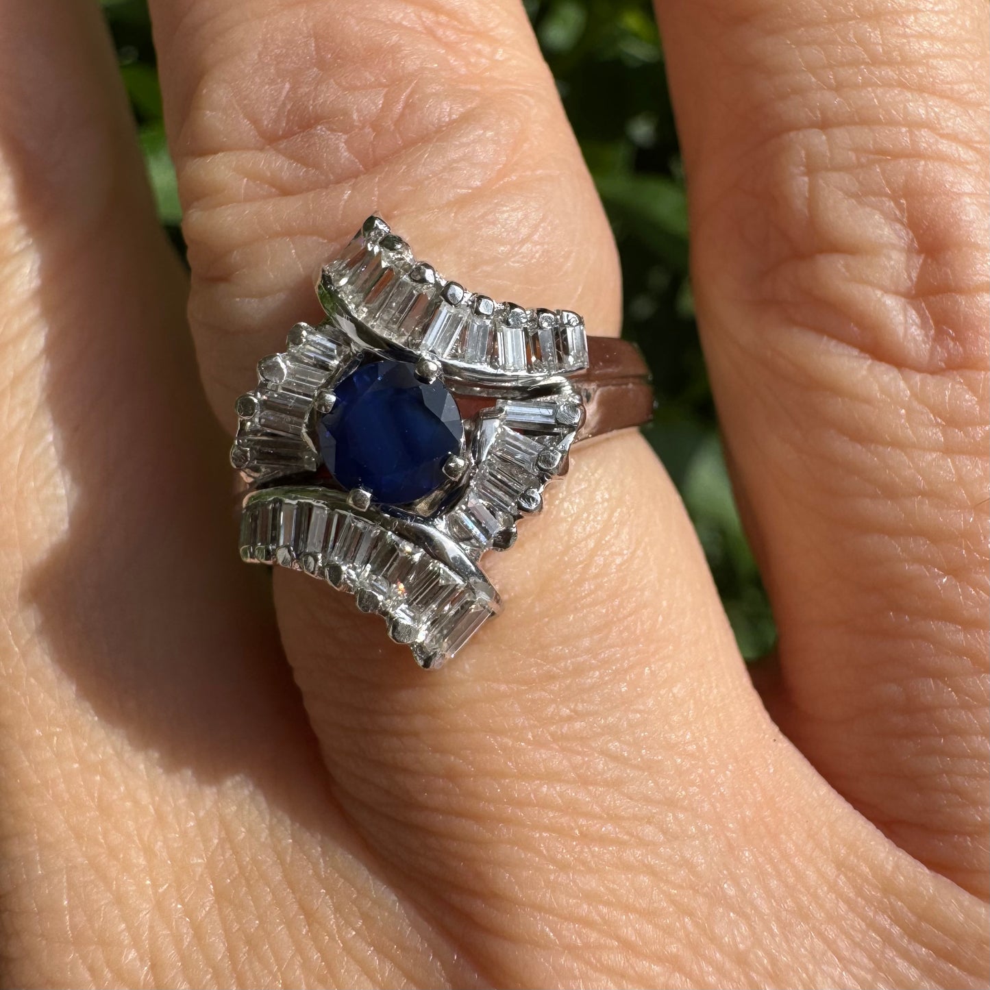 14K gold ring set with a round deep blue sapphire at the center, surrounded by baguette cut Diamonds