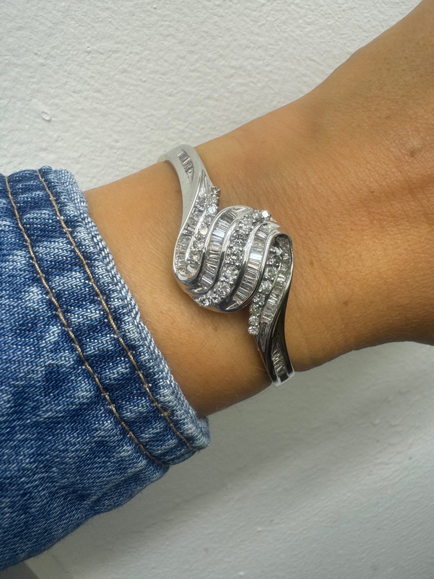 צמיד מרהיב מזהב לבן 14 קראט, בעיצוב גלים דינמי המשובץ בשיבוץ מרוכב של יהלומים עגולים ובחיתוך באגט.