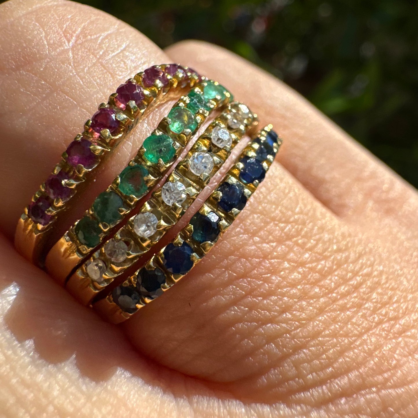 18K yellow gold ring set with vibrant rows of Sapphires, Emeralds, Rubies, and Diamonds