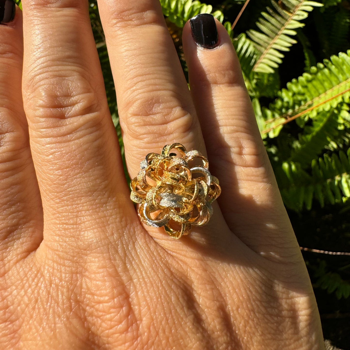18K gold ring set with intricately textured loops in yellow, white, and rose gold, forming a bold floral-inspired sculptural design.