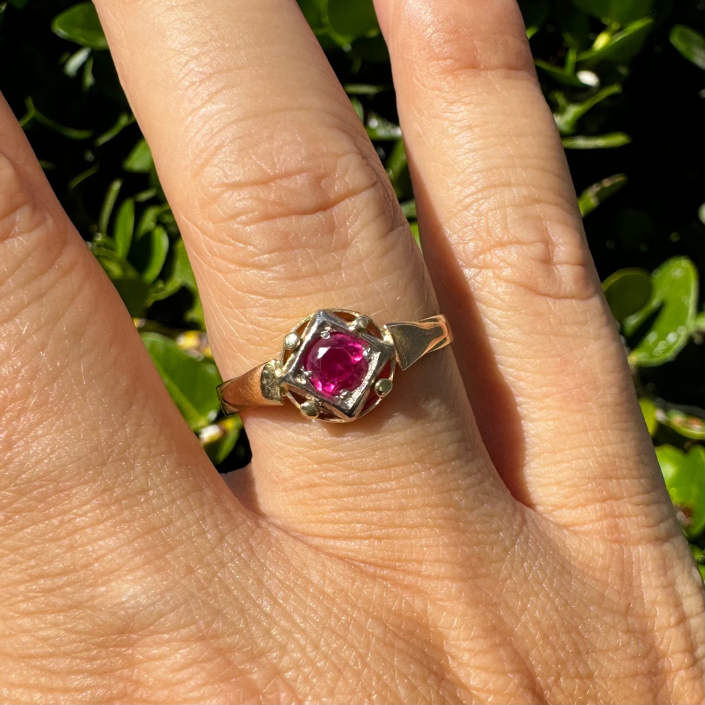 14K gold ring set with a vivid round-cut Ruby set in a geometric white gold frame.