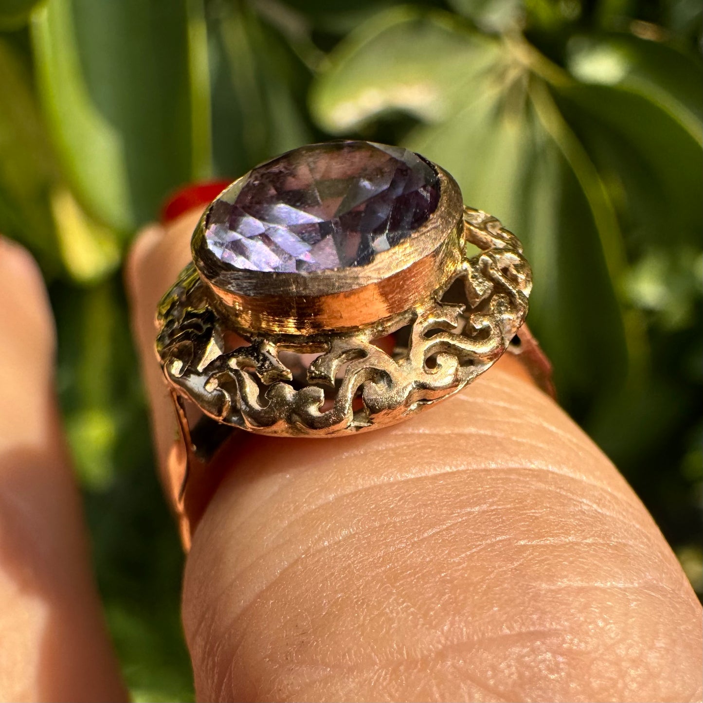 14K gold ring set with a large round-cut Tanzanite framed by an ornate filigree bezel