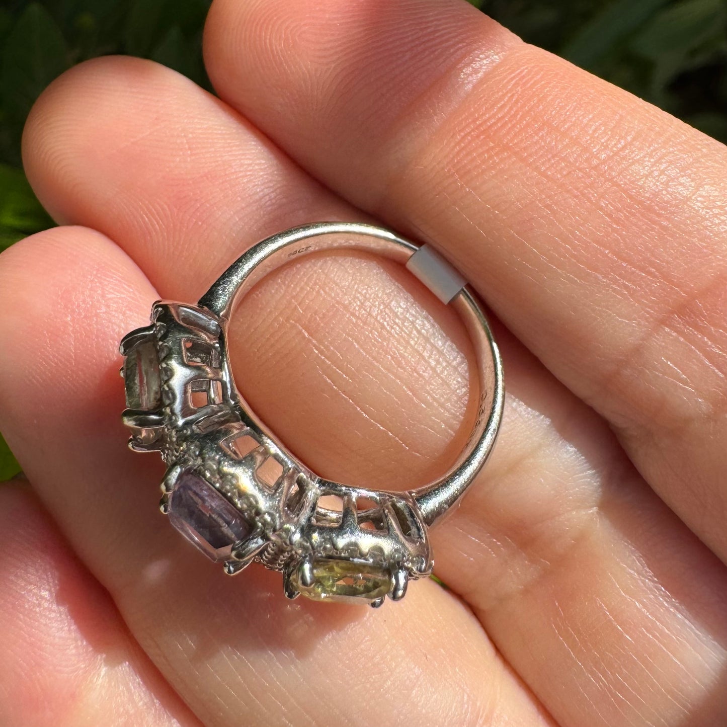 18K gold ring set with three pastel gemstones in soft shades of lilac, yellow and light gray