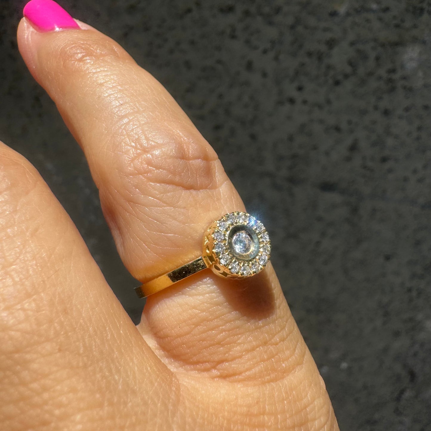 14K gold ring set with a bezel-set central Diamond, surrounded by a sparkling halo of brilliant-cut Diamonds.