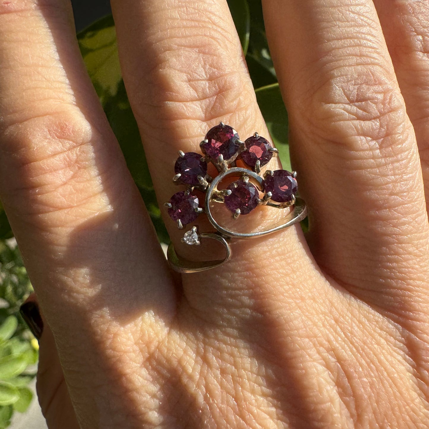 14K gold ring with an open, flowing design, set with multiple pink Tourmaline stones and accented by a Diamond